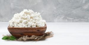 cottage cheese traditional wooden bowl white wooden background close up selective focus with copy space soft curd natural healthy food wholesome diet food