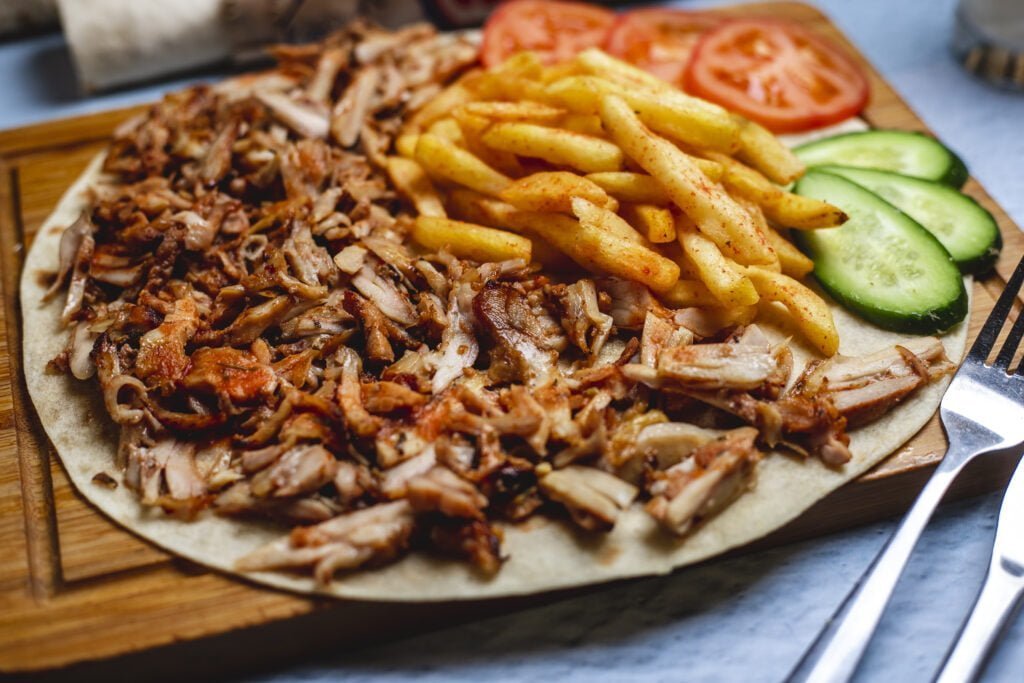 side view doner pita with french fries fresh cucumber tomato
