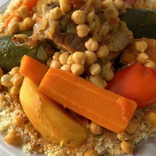 A vibrant dish of Moroccan couscous served with vegetables, chickpeas, and meat.