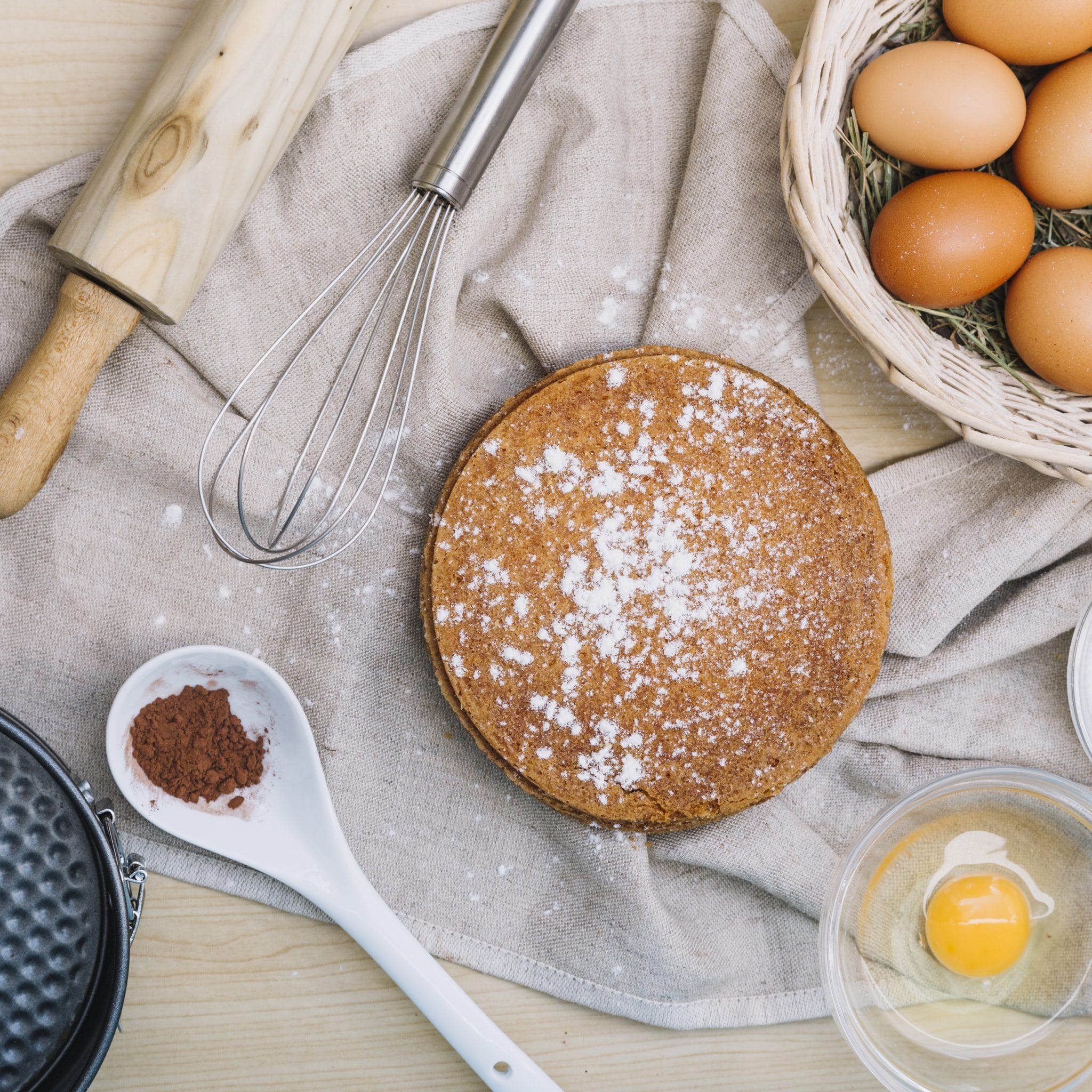Sponge Cake With Icing Sugar And Ingredients On Wooden Table Scaled
